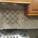 Custom kitchen backsplash with intricate tile design and wood cabinets